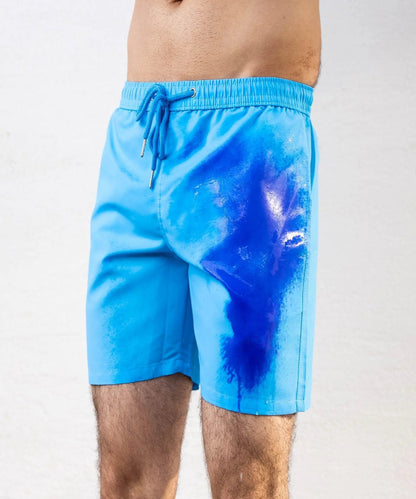 A person wearing bright blue swim shorts with a darker blue abstract splash print on the front, shown against a plain light background.